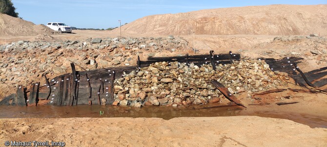 Fouille des épaves des XVIIe-XVIIIe siècles dans la partie amont de l'île Coton, Ancenis (Loire-Atlantique) en 2022. Elles reposent sous et autour de  longues structures empierrées.