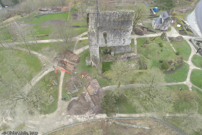 Vue du donjon du château de Domfront (Orne), dont il ne reste que deux pans de murs, hauts de 25 m et épais de 3 à 4 m. Bâti sur un éperon le château était un site de défense sur la frontière sud du duché de Normandie. Un 1er château est construit en bois vers 1010-1020, auquel succède au XIe siècle un château en pierre, renforcé par une courtine au 13e siècle. Occupé par 2 fois par les Anglais durant la Guerre de Cent ans, il est démantelé en 1610 sur ordre de Sully. Les tranchées réalisées en 2022 ont délivré de nouvelles informations sur ce site stratégique.