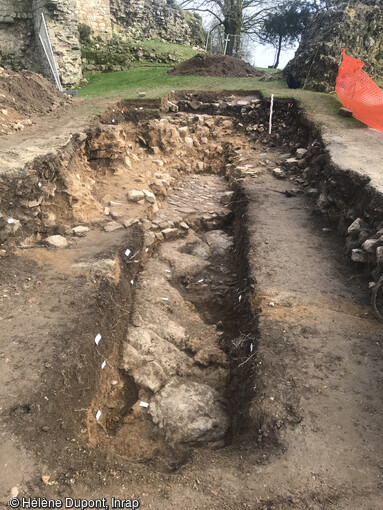 Au pied du donjon, les archéologues ont atteint un pavement correspondant au niveau du sol du château de Domfront (Orne) avant son démantèlement en 1610. 