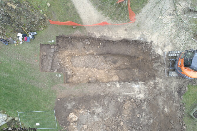 Au pied du donjon, les archéologues ont atteint un pavement correspondant au niveau du sol du château de Domfront (Orne) avant son démantèlement en 1610.