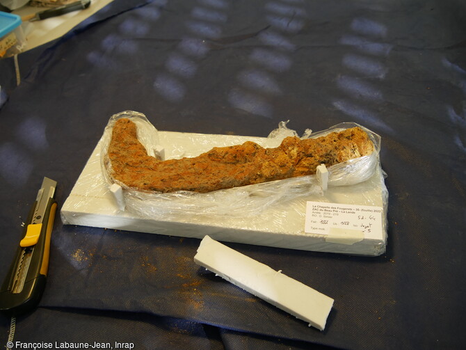 Préparation du conditionnement d'une serpe, mise au jour sur le site gallo-romain de La Chapelle-des-Fougeretz (Ille-et-Vilaine) avant son départ en laboratoire pour stabilisation.