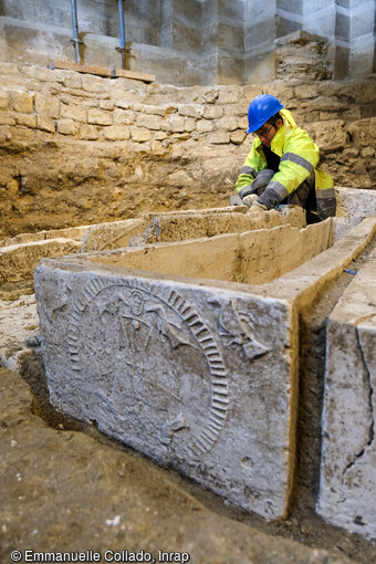 Fouille du massif occidental de la basilique de Saint-Denis (Seine-Saint-Denis), intérieur, bas côté nord, première travée, nettoyage de cuves de sarcophages mérovingiens en plâtre (fin Ve siècle), mars 2023. Responsable d'opération : Ivan Lafarge, Bureau du patrimoine archéologique de Département de la Seine-Saint-Denis.