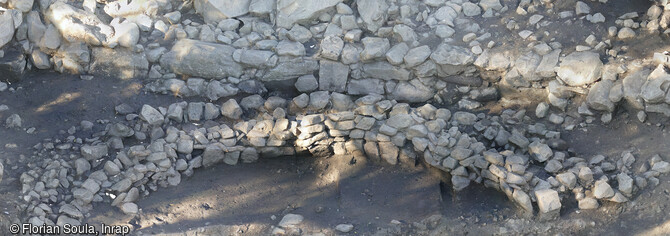 Contrebas d'un bastion implanté sur une terrasse de gros blocs avec une structure en arc de cercle la mieux conservée du site de fouille de Sotta (Corse-du-Sud), en 2023. Un site néolithique y a été mis au jour.