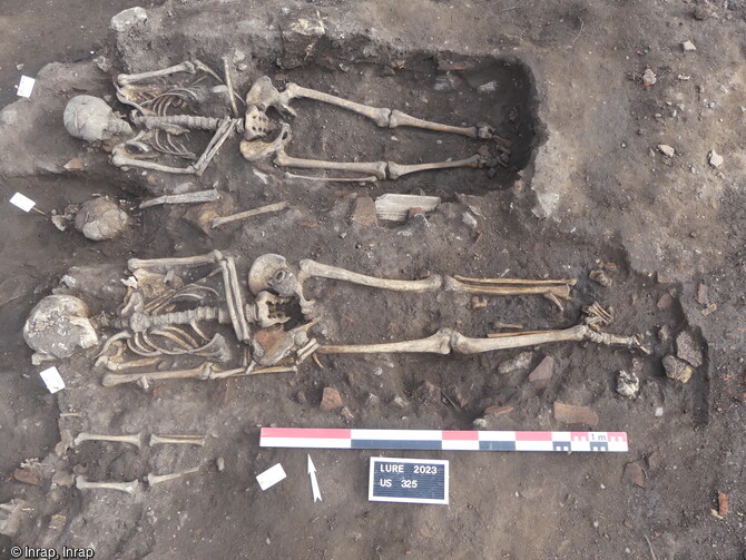 Trois sépultures médiévales formant une rangée, avec deux individus adultes et un immature découverts dans une nécropole  à Lure (Haute-Saône) en 2023. 