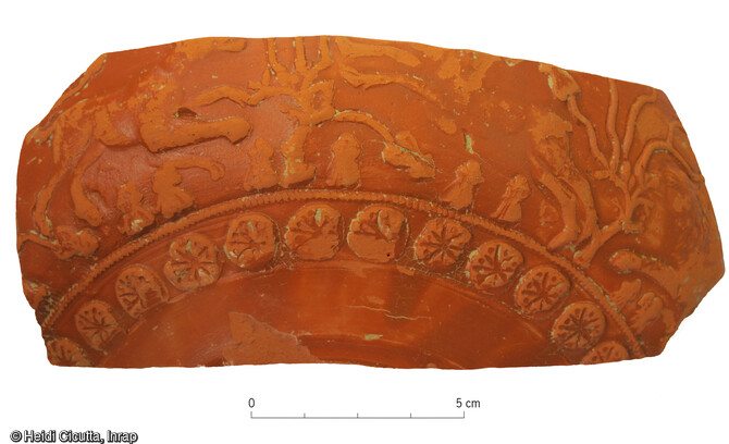 Vue de détail d'un fragment de coupe sigillée provenant du sondage réalisé dans la descente de la cave antique et décoré de guillochis.