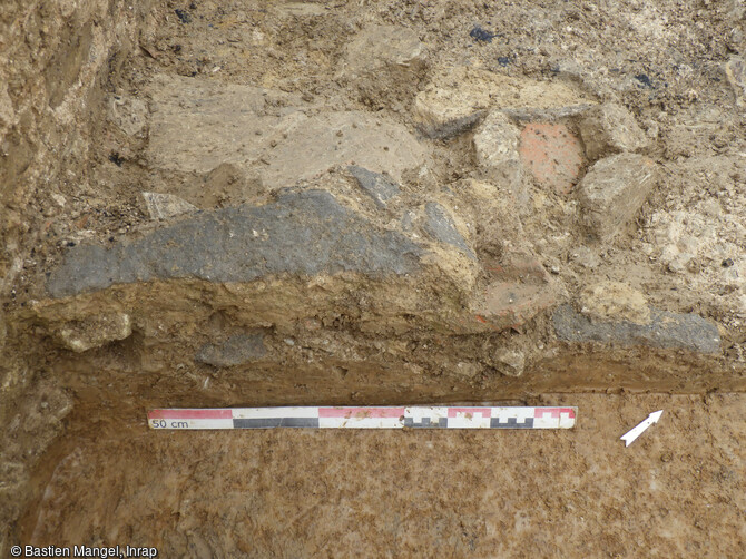 Vue d'un fragment de cloison en terre crue effondré au fond de la cave de la villa antique de Lemud (Moselle). Les premières observations montrent qu'il s'agit d'une maçonnerie en terre crue sans ossature en bois, c'est à dire d'un mur en adobes (briques en terre crue) ou en pisé (terre coffrée), et non en torchis sur un clayonnage de bois. Ces techniques architecturales restent assez exceptionnelles dans le nord de la Gaule, à fortiori en contexte rural. 