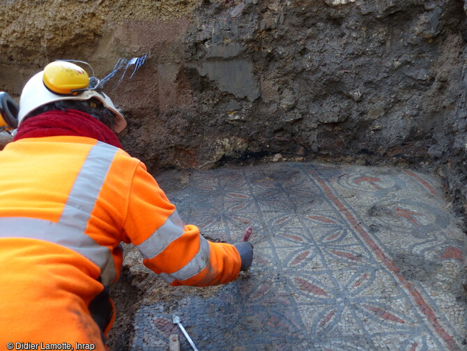 Nettoyage de la mosaïque mise au jour dans le centre historique de Nevers (Nièvre). A 2,50 m au sud-ouest du baptistère paléochrétien, et à une profondeur de 1,40 m, ce sol se trouve sensiblement à la même altitude que les seuils de pierre permettant l'accès à la cuve baptismale. 