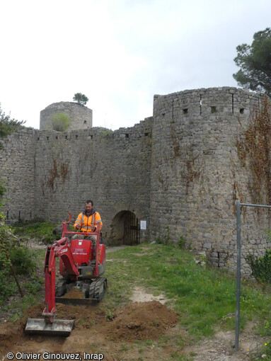 Sondage mécanique en cours aux abords septentrionaux du flanc nord de la fortification du château de Clermont-L'Hérault (Hérault) en 2021. 