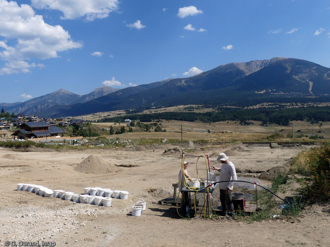 Tamisage sur le site de la fouille de Bolquère (Pyrénées-Orientales) en 2023. Pour tenter de comprendre le fonctionnement, l'évolution et la chronologie du site, les échantillonnages en sédimentologie, palynologie, xylologie et anthracologie nécessitent de nombreux tamisages. Tout laisse envisager que le contexte environnemental constitue le principal point attractif du lieu et que ce sont ces conditions favorables qui conditionnent les installations. 