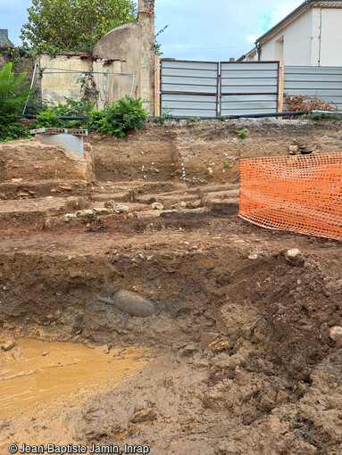 Entrepôt dans le quartier du port fluvial antique à Narbonne (Aude) en cours de fouille en 2023. De nombreuses amphores, dont ici une entière, ont été réutilisées pour constituer un vide sanitaire sous un sol en terre ou en béton.