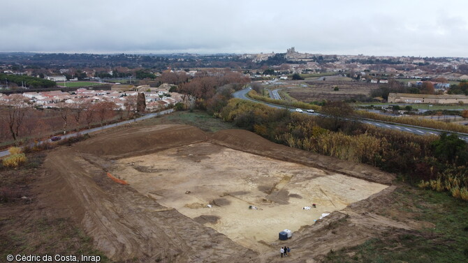 Vue aérienne de l'emprise de la fouille de 4000 m2 depuis le sud-ouest sur le site des Fangasses à Béziers (Hérault). Les archéologues ont documenté des aménagements protohistoriques, notamment une maison à abside bien conservée, des fosses du Néolithique, dont cinq inhumations, ainsi qu'une plantation d'arbres de l'époque romaine. 