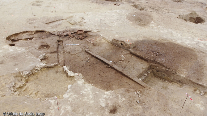 Photographie générale de l'occupation de l'âge du Fer avec une  maison en arrière-plan à Béziers (Hérault). 