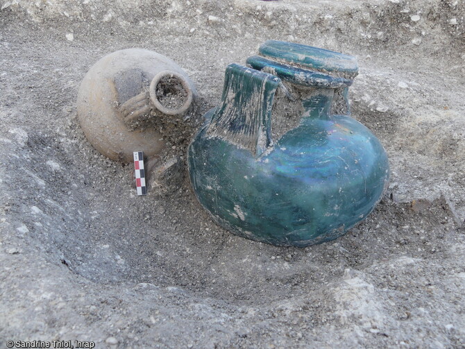 Urne en verre et cruche déposées dans une sépulture à incinération dans la nécropole antique de la rue Soussillon à Reims (Marne).