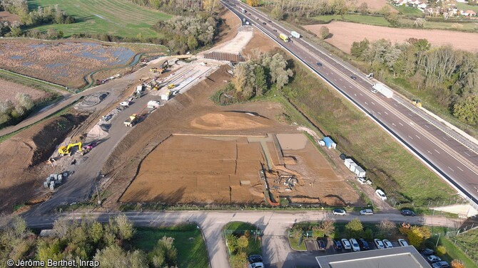 Vue aérienne de la fouille archéologique du site solutréen de Fragnes-La-Loyère (Saône-et-Loire). Au fond, la vallée de la Thalie ; à gauche, les travaux de l'échangeur autoroutier et à droite, l'autoroute A6. 