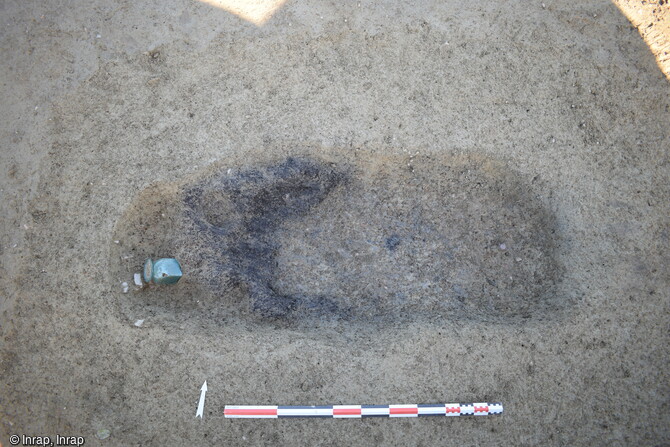 Fosse à incinération et son urne en verre à une extrémité mis au jour dans la nécropole antique de Noyal-Châtillon-sur-Seiche (Ille-et-Vilaine). La présence d'urne en verre indique le statut élevé des occupants. 