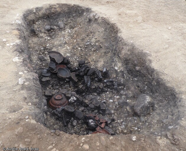 Un exemple de bûcher en fosse avec des dépôts de céramique, daté entre 15 et 60 de notre ère, découvert dans l'ensemble funéraire antique de Saint-Vulbas (Ain).