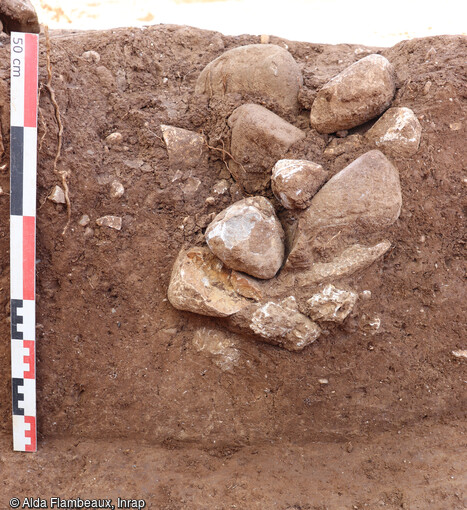 Vue en coupe d'un trou de poteau de l'âge du Bronze sur le site d'Aubagne (Bouches-du-Rhône). Tous les trous de poteau sur le site possèdent des pierres et/ou des blocs de calage ajoutés dans les creusements pour maintenir les poteaux en place et renforcer leur assise. 