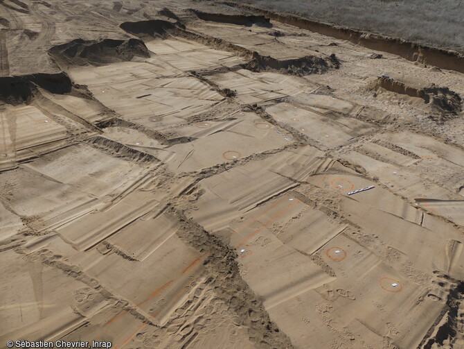 Vue aérienne de la zone 3 dont les trous de poteaux dessinent un plan de bâtiment quadrangulaire difficilement datable. Cette fouille, a été menée dans un contexte géomorphologique très particulier. Les formations sédimentaires superficielles sont constituées de sables éolisés.