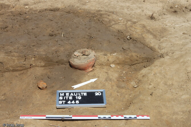 Détail du vase posé au pied du défunt et d'un clou de coffrage  dans une inhumation isolée datée du IVe siècle mise au jour dans la cour de la ferme romaine à Méaulte (Somme).