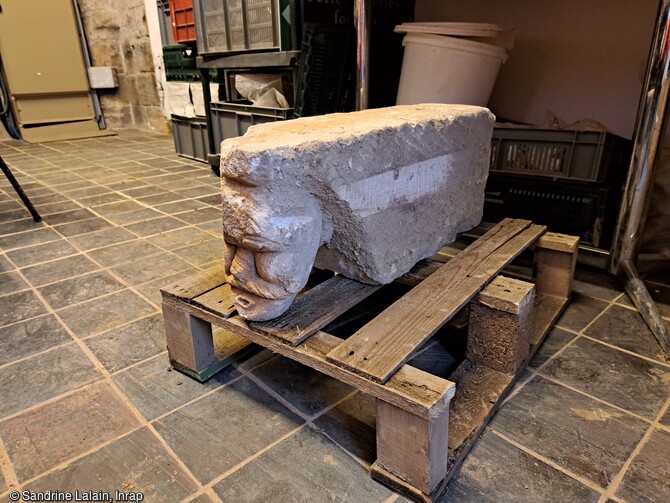 Mise au jour d'un modillon du XIIe siècle réemployé dans un mur de la période moderne, et représentant un homme moustachu en train de souffler, au Château de Caen (Calvados). 