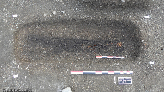 Apparition des vestiges ligneux en surface de la tombe SP 8, attribuée à l'époque médiévale à Publier (Haute-Savoie). Il pourrait s'agir d'un dispositif de couverture de coffrage en bois (non cloué). 