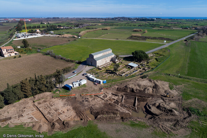 Vue aérienne la fouille du mithræum et de ses annexes, érigé autour de l'an 100 de notre ère sur le site de l'antique colonie romaine de Mariana à Lucciana (Haute-Corse). A l'arrière-plan l'église romane de la Canonica. 