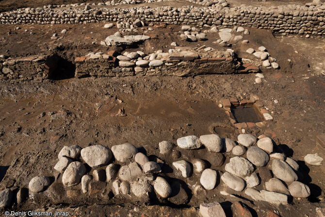 Les deux banquettes parallèles du mithræum, érigé autour de l'an 100 de notre ère sur le site de l'antique colonie romaine de Mariana à Lucciana (Haute-Corse) avec au centre un aménagement en briques.