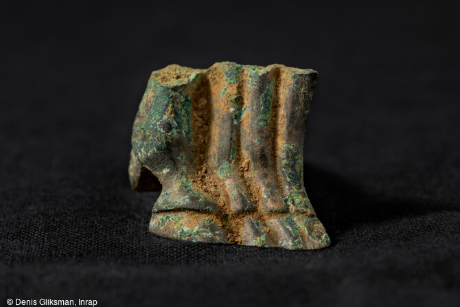 Retrouvé dans la tombe princière de  la Dame de Vix  datant de 500-490 av. notre ère, au cours de la fouille de 2019 à Vix (Côte-d'Or), ce petit fragment de bronze décoré de bas de pattes de chevaux était jusqu'à présent le seul élément manquant sur la frise de quadriges et de hoplites décorant la cratère grec mis au jour en 1953. 
