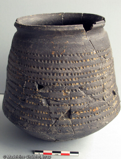 Pot en céramique entier découvert dans une des tombes du site d'Eckwersheim (Bas-Rhin). Cette céramique tournée biconique est la plus représentative de la civilisation mérovingienne et est connue essentiellement dans le contexte funéraire. Elle devait accompagner le défunt vers le royaume des morts. Sa datation est ici estimée au VIe siècle.