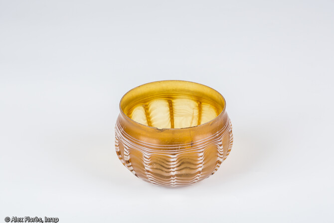 Gobelet nervuré jaune et blanc, en verre, découvert dans les dépôts de crémation de la nécropole romaine (Ier-IIe siècle) d’Eckwersheim (Bas-Rhin).