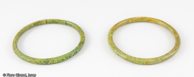 Paire de bracelets en alliage cuivreux ornés de décors incisés.