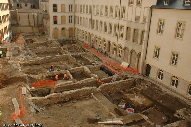 Vue aérienne de la fouille menée dans la cour de l'ancienne école Sainte-Chrétienne à Metz (Moselle) en 2009.  L'opération, menée sur une superficie de 1800 m2, a révélé une partie du couvent des Carmélites (fondé en 1623) déjà connu par des archives. Grâce à l'étude des élévations conservées dans le bâti contemporain et aux vestiges mis au jour par la fouille, un plan bien plus complexe que celui des archives a pu été dressé. 