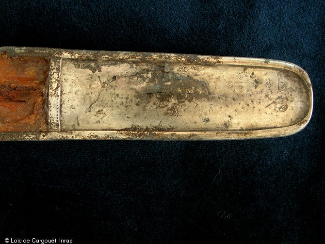 Détail sur la bouterolle de l'épée découverte dans la sépulture aristocratique n° 13 de Saint-Dizier (Haute-Marne) qui est datée du VIe s. de notre ère, 2002.  Longue de 90 cm environ, l'épée avait été placée contre l'épaule droite du défunt et était conservée dans son fourreau en bois d'aulne.  