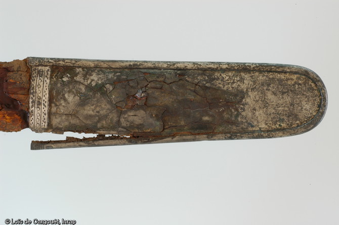 Détail sur la bouterolle de l'épée découverte dans la sépulture aristocratique n° 11 de Saint-Dizier (Haute-Marne) qui est datée du VIe s. de notre ère, 2002.  Longue de 90 cm environ, l'épée avait été placée contre l'épaule droite du défunt et était conservée dans son fourreau en bois d'aulne.  