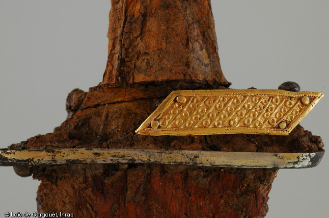 Détail sur le quillon en tôle d'argent doré  - orné d’une applique décorative en or - de l'épée découverte dans la sépulture aristocratique n° 11 de Saint-Dizier (Haute-Marne) qui est datée du VIe s. de notre ère, 2002. 