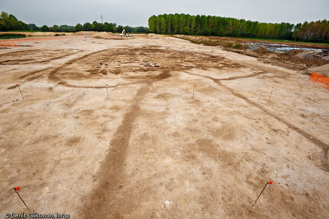 Une équipe d'archéologues de l'Inrap a étudié un site néolithique à Pont-sur-Seine (Aube) sur une surface de 4 hectares en 2009. Le village mis au jour est exceptionnel par la densité de l'occupation, la monumentalité des bâtiments et le caractère inédit de certaines architectures. Ici, une vue générale du bâtiment monumental principal (900m2). Au premier plan, les lignes marron au sol dessinent le couloir d'accès à ce bâtiment. Ce couloir se matérialisait par une palissade en bois de 2 mètres de haut.