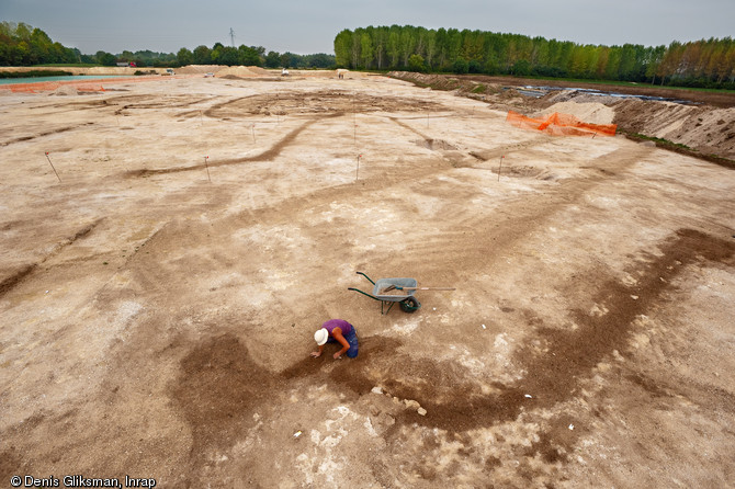 Une équipe d'archéologues de l'Inrap a étudié un site néolithique à Pont-sur-Seine (Aube) sur une surface de 4 hectares en 2009. Le village mis au jour est exceptionnel par la densité de l'occupation, la monumentalité des bâtiments et le caractère inédit de certaines architectures. Ici, nous observons la fouille de l'entrée de l'enclos intégrant les bâtiments monumentaux, la palissade de 2 mètres de haut s'interrompt dans l'axe du bâtiment principal. Dès cette entrée, la stature des bâtiments devait se révéler en un coup d'œil.