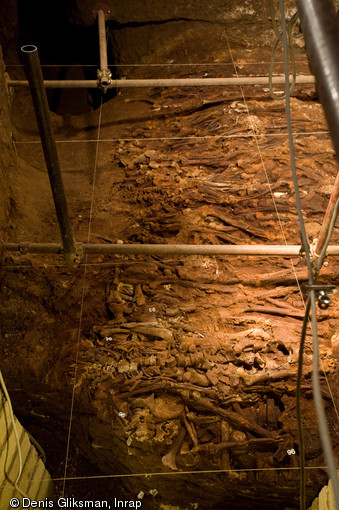 Amas de squelettes en connexion. Fouille de la catacombe des saints Pierre et Marcellin à Rome, 2008.  Entre 2005 et 2008, un programme de fouilles a été engagé permettant la mise au jour d'un nombre considérable d'ossements humains sur une épaisseur de près d'un mètre dans un secteur encore inexploré de la catacombe, ici la tombe X83.