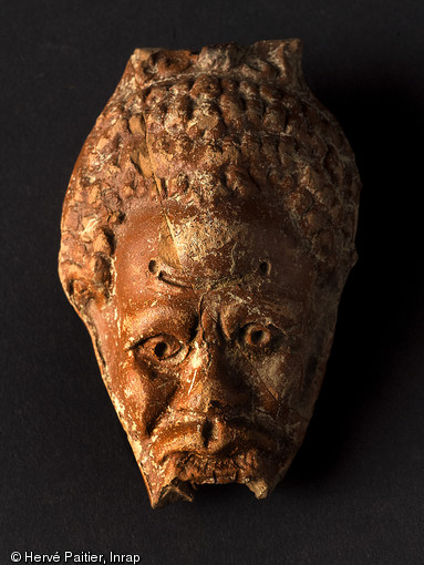 Fragment d'un lustre en terre cuite au faciès de Nubien, IIIe s. de notre ère, découvert au cours de la fouille du sanctuaire voué au culte de Mithra à Angers (Maine-et-Loire), 2010. 