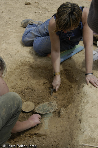 Dégagement d'une casserole en bronze dans une des tombes de la nécropole de Saint-Marcel (Morbihan), Ve s. de notre ère, 2006. 