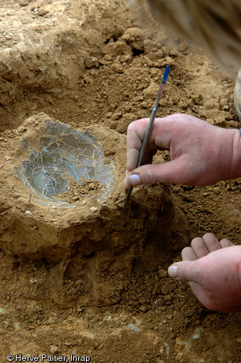 Fouille fine d'une des sépultures de la nécropole de Saint-Marcel (Morbihan), Ve s. de notre ère, 2006.  Cette méthode permet de dégager des objets extrêmement fragiles comme cette coupe en verre. 