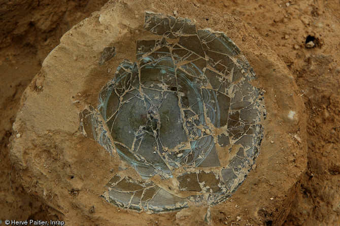 Coupe en verre ornée de filets blancs opaques disposés à l'horizontale associés à des festons piqués et d'entrelacs mise au jour dans une des sépultures de la nécropole de Saint-Marcel (Morbihan), Ve s. de notre ère, 2006. 