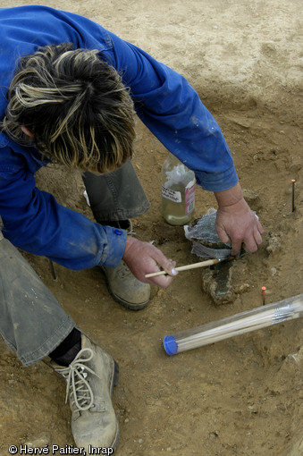 Consolidation et prélèvement d'une casserole en bronze mise au jour dans une des sépultures de la nécropole de Saint-Marcel (Morbihan), Ve s. de notre ère, 2006. 