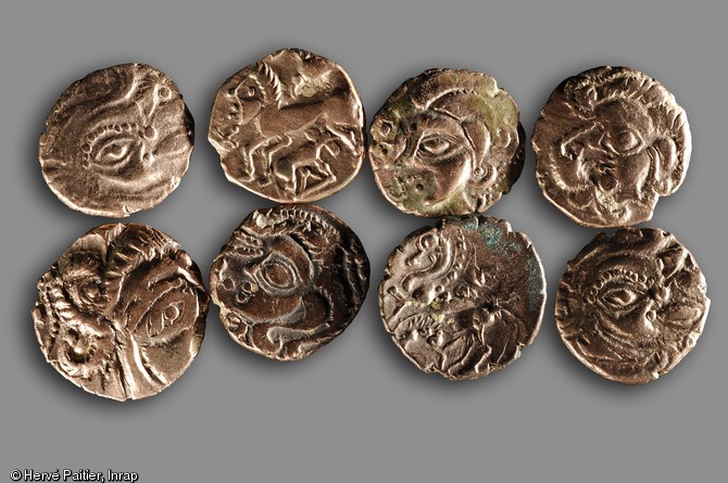 Huit pièces (statères et quarts de statères) en électrum (alliage d'or et d'argent) du trésor enfoui vers 50 avant notre ère à Laniscat (Côtes-d'Armor), 2007. 
