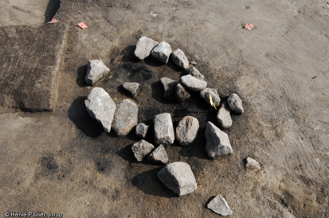 Structure de combustion à Carnac sur le site Néolithique moyen (4500 avant notre ère) de Montauban (Ille-et-Vilaine), 2009.  Les structures de combustion mises au jour à Montauban sont de dimensions assez standardisées (1m de diamètre environ) et sont comblées par des pierres jointives plus ou moins rubéfiées. 