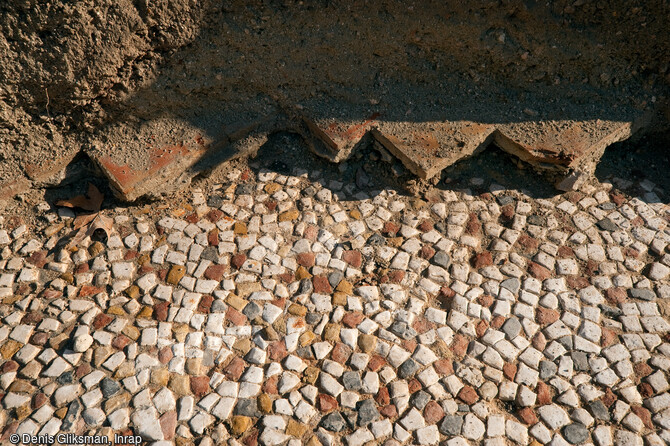 Pavement romain du Ier s. avant notre ère. Fouille de l'Hôtel-Dieu à Marseille, 2010.  Ces sols, utilisés jusqu'au XIXe s., sont constitués de grosses tesselles irrégulières de pierres blanches, noires, jaunes et rouges (opus de style délien) et faisaient peut-être partie d’un habitat privilégié dominant le port.