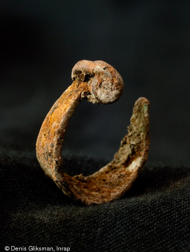 Fibule fragmentaire et déformée en bronze, VIe s. avant notre ère. Fouille du site de la Cougourlude à Lattes (Hérault), 2010. 