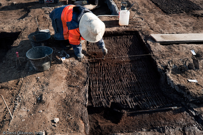 Dégagement des vanneries des cuves de tannage (XIVe-XVe s.), fouille du site de l'Hôtel du Département à Troyes (Aube), 2010.  La formation naturelle de niveaux de tourbe a permis une excellente conservation des matériaux organiques comme ces vanneries. 