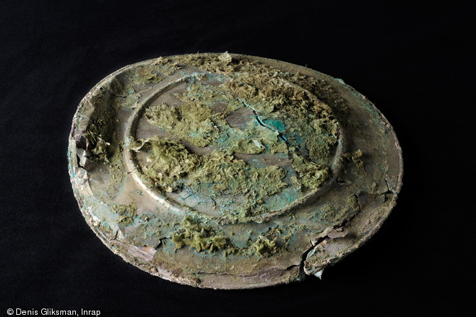 Arrière d'un plat rond en bronze recouvert d'une feuille d'argent, IIe-IIIe s. de notre ère, Reims (Marne), 2009.  Les traces verdâtres sur la surface de l'objet sont les restes de la fourrure qui le protégeait. 