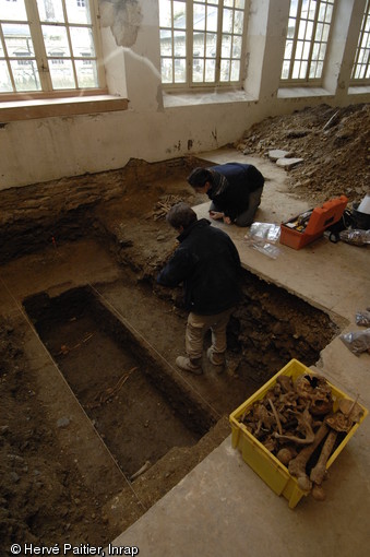 Sépulture moderne (XVe - XVIIe s.) mise au jour dans un sondage réalisé dans le couvent des Jacobins à Rennes (Ille-et-Vilaine), 2007.  Ici, le squelette a déjà été dégagé et enregistré : les archéologues l'ont alors prélevé afin de continuer le sondage.